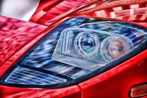 Phare avant d'une voiture rouge, détail lumineux et design