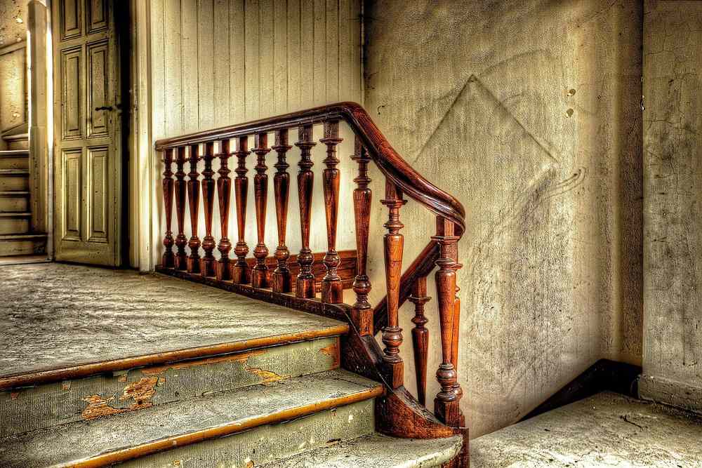 Escalier avec rampe en bois et mur en béton